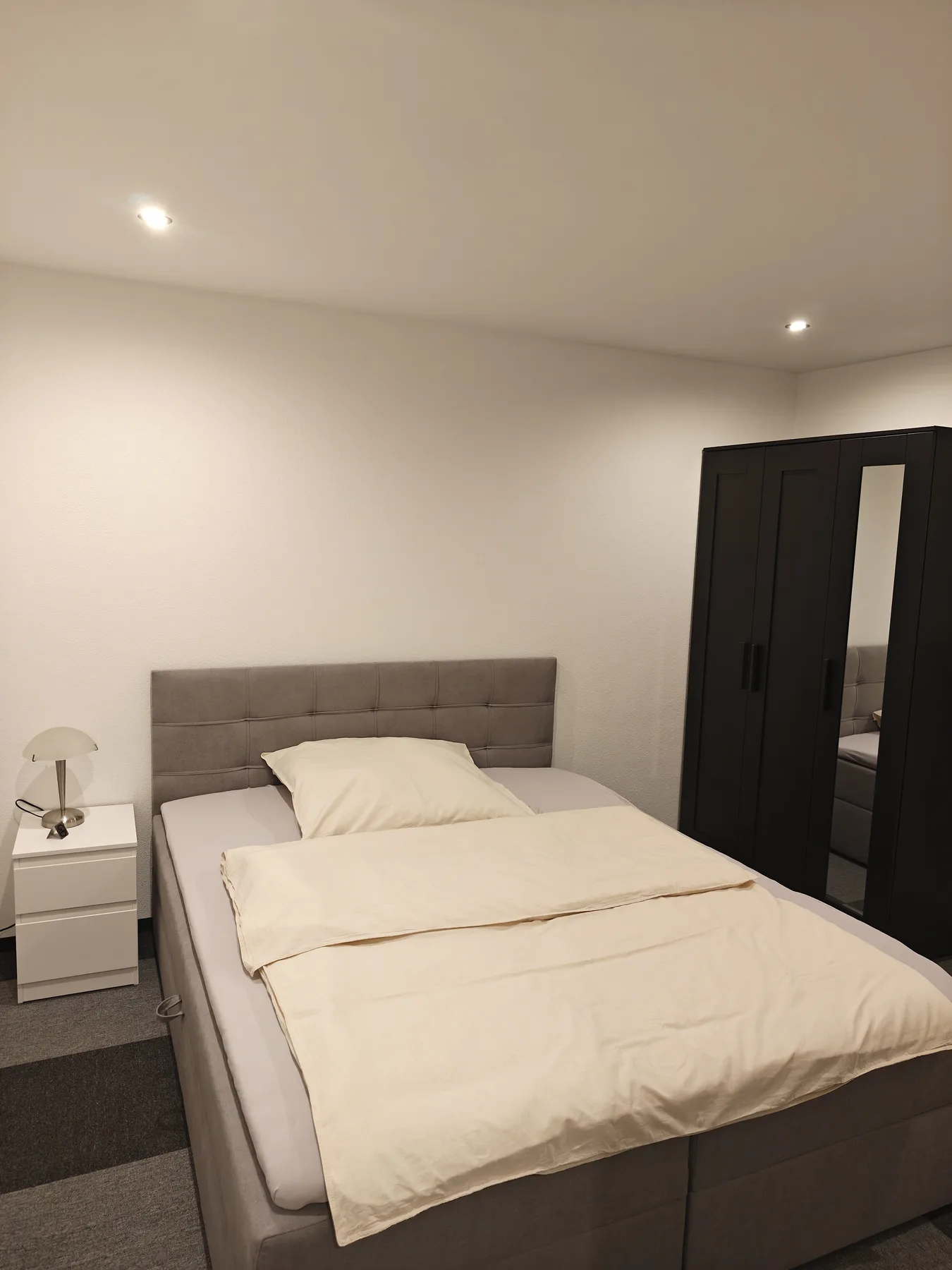 Schlafzimmer mit Doppelbett, Nachttisch und Kleiderschrank