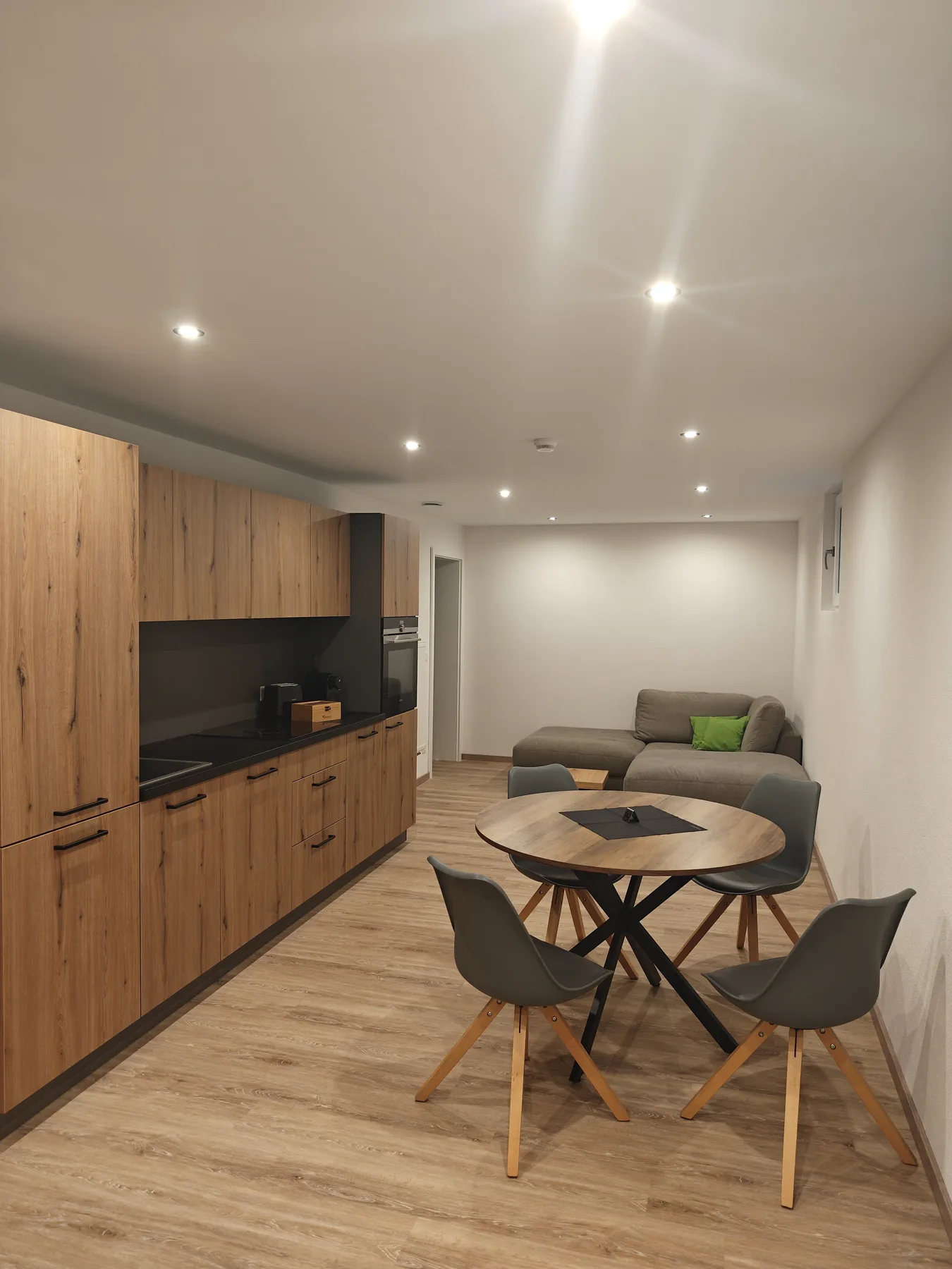 Wohnküche der Monteurwohnung mit Küchenzeile, rundem Esstisch und Sitzecke
